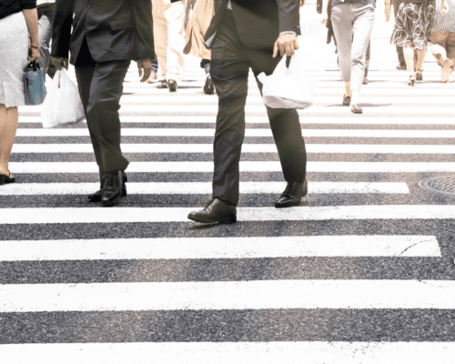 Pedestrians in a large walkway of a busy street.