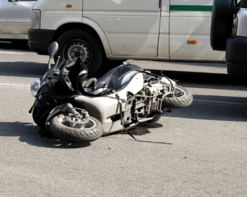 A motorcycle on the ground next to a car.